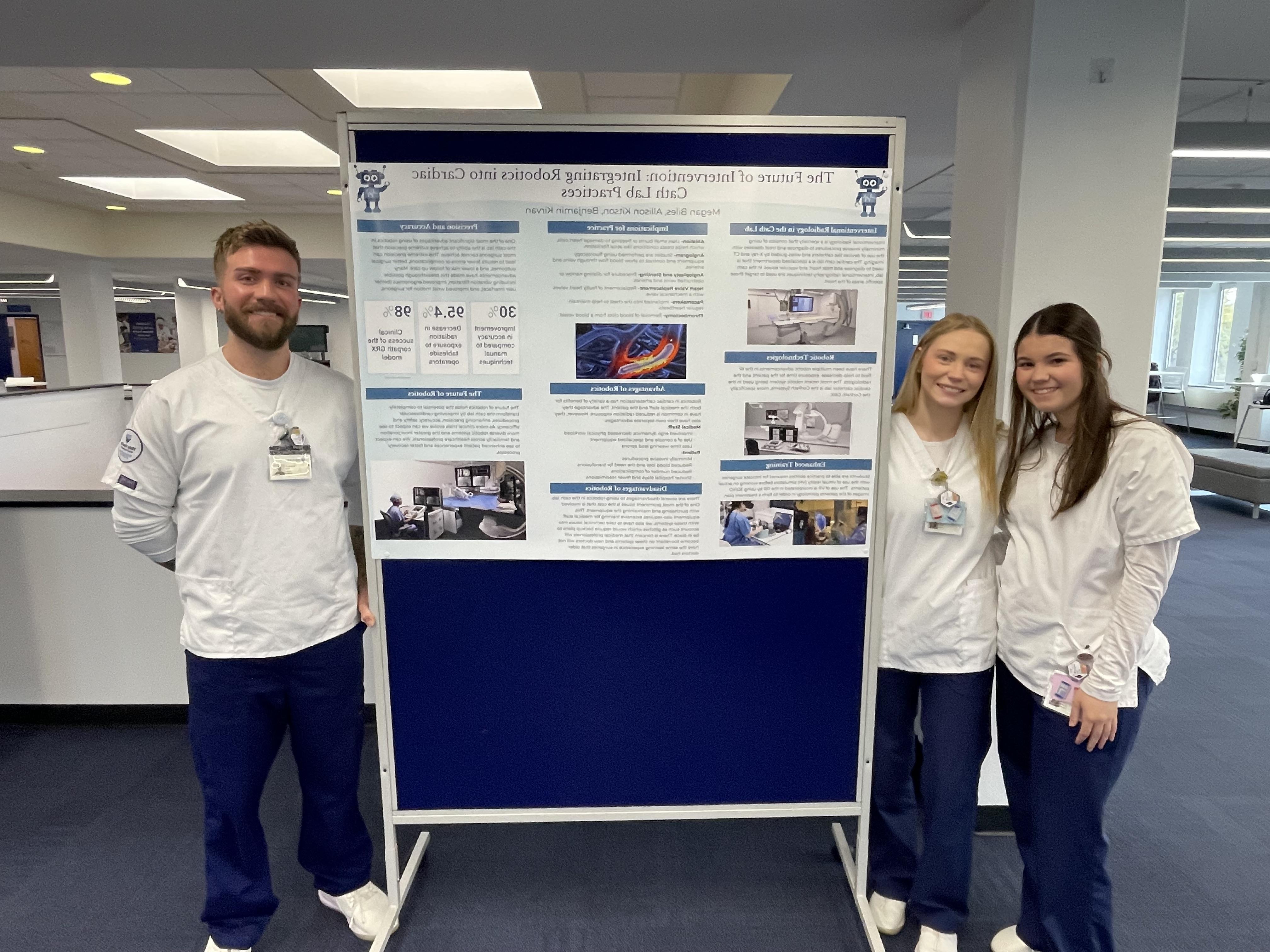 Students present poster on use of robotics in cath lab.